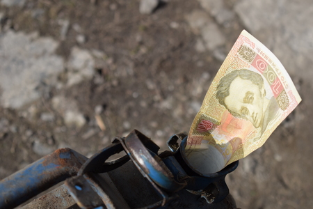 Metal barrel and Ukrainian money, the concept of the cost of gasoline, diesel, gas. Refilling the car.の写真素材