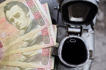 Metal barrel and Ukrainian money, the concept of the cost of gasoline, diesel, gas. Refilling the car.の写真素材