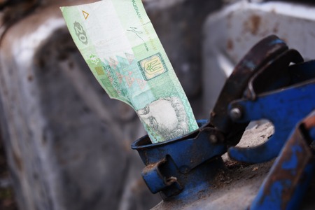 Metal barrel and Ukrainian money, the concept of the cost of gasoline, diesel, gas. Refilling the car.の写真素材