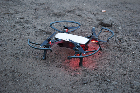 A drone with a red backlight is preparing for takeoff, new technologies in aerial photography.の写真素材