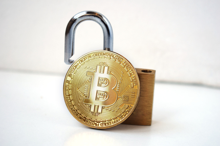 Bitcoin security concept. Gold coin with padlock on a light background..の写真素材