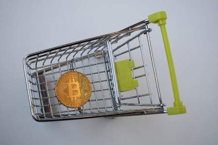 Shopping cart and bitcoin. Concept of cryptocurrency market, buying cryptocurrency, investing in new money.の写真素材