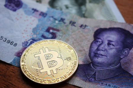 Bitcoin Gold Coin on Chinese Yuan banknotes. Close up.の写真素材