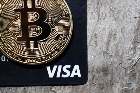 Ukraine, Kremenchug - March, 2019: Golden Bitcoin on Visa cardのeditorial素材