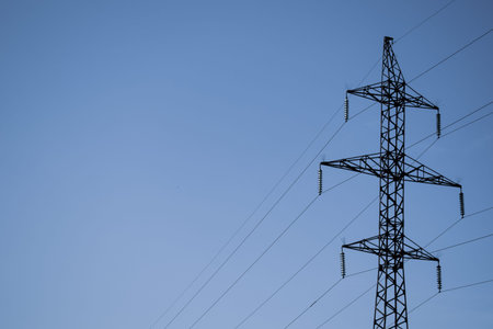 High voltage tower on the against the blue sky.