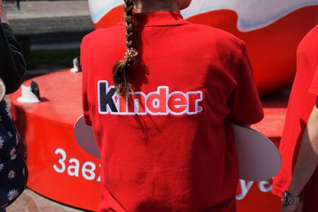 Ukraine, Lviv - May, 2019: Girl in a red T-shirt with the Kinder logo.のeditorial素材