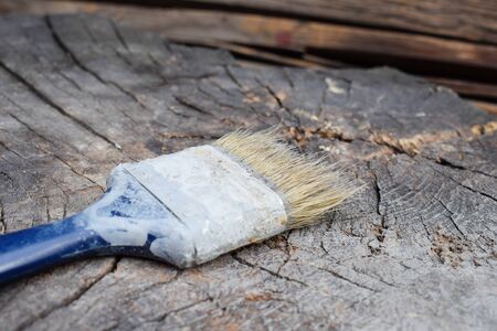 Brush on a wooden background. Painting wooden surface. Old brush. Gray paint.の写真素材
