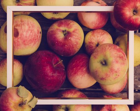 Apples on a wooden background with white frame. Apples contain many vitamins.の写真素材