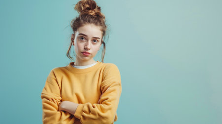 portrait of a teenage girl in a yellow sweater on a blue backgroundの素材