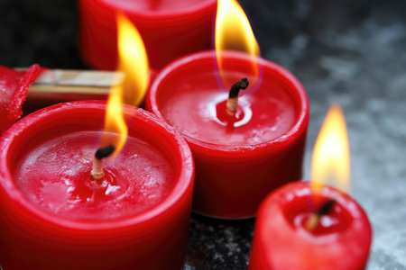 Burning red candles on dark background. Shallow depth of fieldの素材