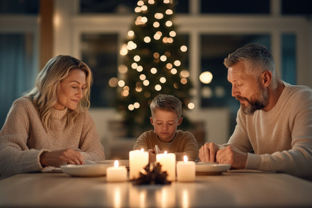 family, holidays, generation, christmas and people concept - happy family with burning candles at homeの素材