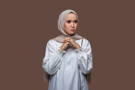 Beautiful woman in hijab is holding a mobile phone and showing it forwardの写真素材