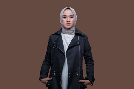 Cool woman wearing hijab posing on plain backgroundの写真素材