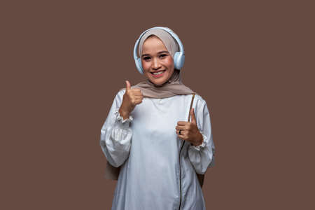 Young hijab woman using wireless headphones enjoy listening musicの写真素材