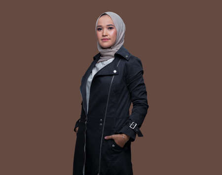 Cool woman wearing hijab posing on plain backgroundの写真素材
