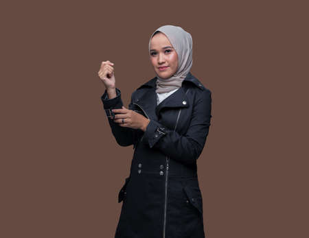 Asian woman wearing hijab posing on plain backgroundの写真素材