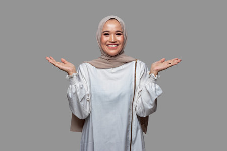 Hijab woman spread the palms sideways hand gesture isolated on plain background.の写真素材