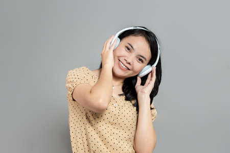 Beautiful woman holding like a pizza box and pointing up with index fingerの写真素材