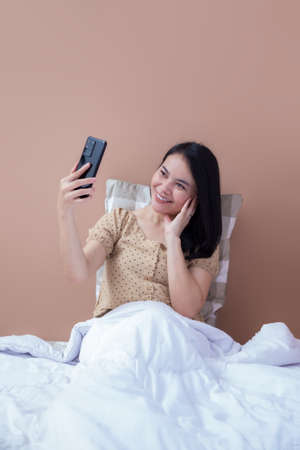 Beautiful woman holding like a pizza box and pointing up with index fingerの写真素材