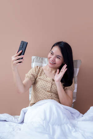 Beautiful woman holding like a pizza box and pointing up with index fingerの写真素材