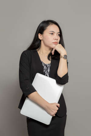 Shocked business woman holding and looking at laptop screenの写真素材