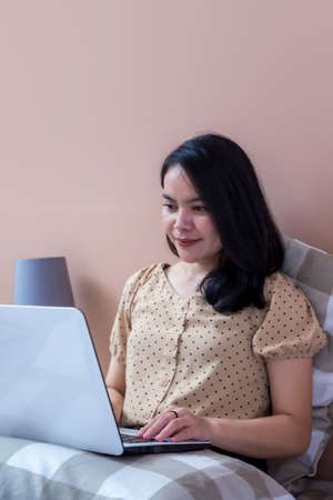 Beautiful woman is imagining while holding a pen and clipboardの写真素材