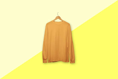 Marigold long sleeve t-shirt on wooden hanger isolated on backgroundの写真素材