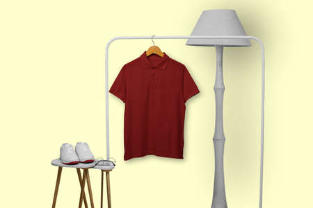 Maroon polo shirt hanging on rack isolated on plain backgroundの写真素材