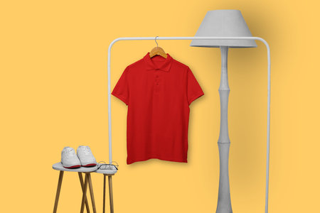 Red polo shirt hanging on rack isolated on plain backgroundの写真素材