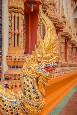 Ancient Thai temple. Wat Kosit Wihan golden Temple Phuket, Thailand. Stairs entrance dragons.の写真素材