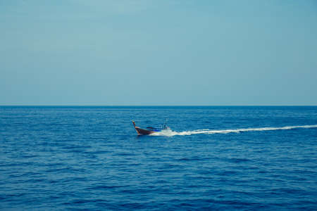 Wooden boat sailing on blue sea ocean.の写真素材