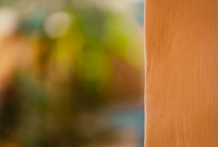 Close up shot of orange color painted wall with a blurred natural bokeh background for advertising slogan.の写真素材