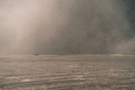 A foggy landscape with a large flat sand surface. Bromo, Indonesia