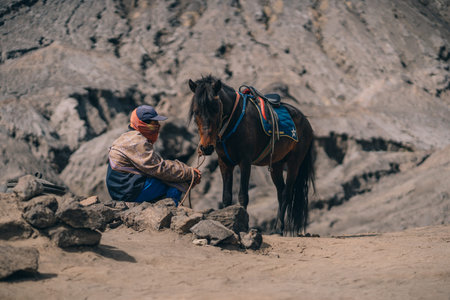 Close up shot of unrecognized tenggerese horseman waiting for tourists. Horse trip in Bromo Mount...