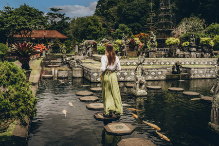 Girl walking in Saraswati temple water. Pura Taman Kemuda Saraswati, Ubud water palaceの写真素材