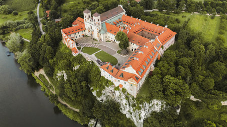 Aerial view of Benedictine abbey of Saints Peter and Paul in Tyniec, Poland. Panoramic view from drone of monastery courtyard, roofs and towers of stone buildings, green lawn of catholic churchの写真素材
