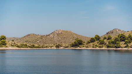 Idyllic seashore view with hills of Dugi Otok island in distance, blue waters of Adriatic Sea, Croatiaの写真素材