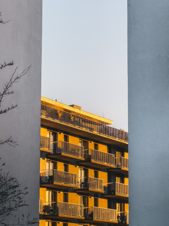 Residential apartment building with balconies framed by two concrete walls, capturing the urban living and architectural design of modern housing.の写真素材