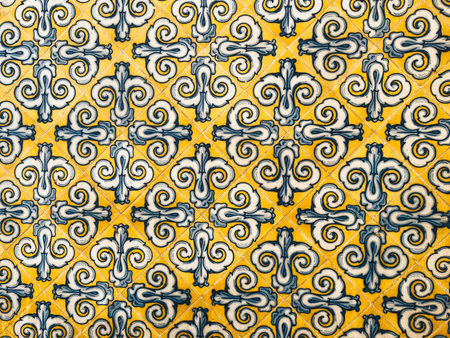 Close-up of decorative tiles featuring a blue and yellow geometric pattern, highlighting intricate design and craftsmanship in traditional tilework.の写真素材
