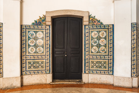 Elegant black door framed by colorful Portuguese azulejo tiles in Lisbon, perfect for travel, architecture, and design inspiration or cultural heritage projects.の写真素材