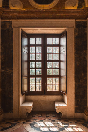 Beautiful sunlit window with classic stone benches and ornate details in a historic Lisbon palace,...