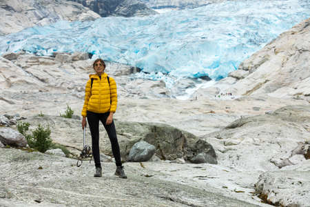 A woman is posing on the rock formation of Jostedal Glacierの写真素材