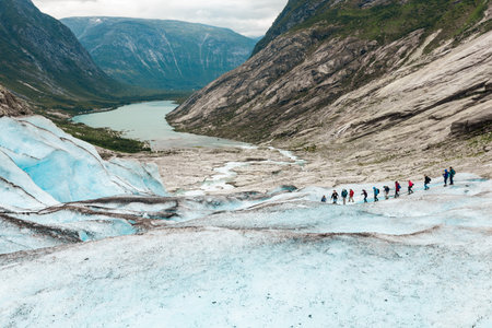 Tourists are climbing down from the branch of Jostedal Glacier