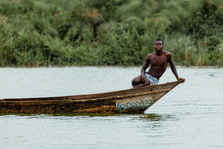 A local man sitting on the edge of his canoe. Queen Elizabeth National Park, Uganda