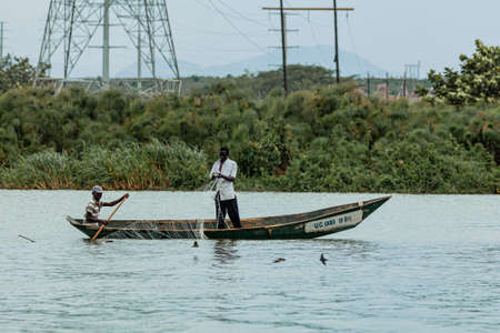 QUEEN ELIZABETH NATIONAL PARK, UGANDA - MARCH 14, 2018: An unidentified fisherman stands in the canoe and arranges a net on March 14, 2018 in Queen Elizabeth National Park, Ugandaのeditorial素材