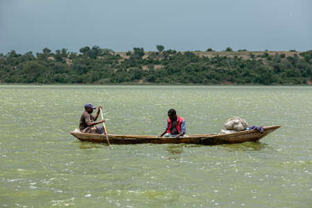 QUEEN ELIZABETH NATIONAL PARK, UGANDA - MARCH 14, 2018: Unidentified local men in the canoe in Kazinga Channel on March 14, 2018 in Queen Elizabeth National Park, Ugandaのeditorial素材