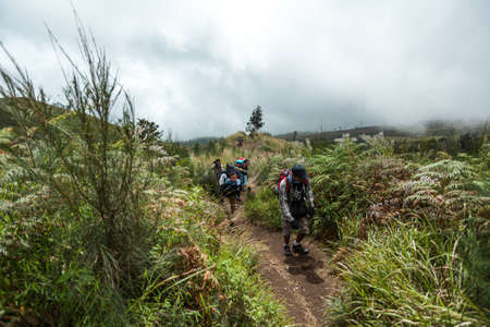 MOUNT RINJANI NATIONAL PARK, INDONESIA - JULY 22, 2016: People go uphill on the narrow footpath. Trek to Mount Rinjani on July 22, 2016 in Mount Rinjani National Park, Indonesiaのeditorial素材