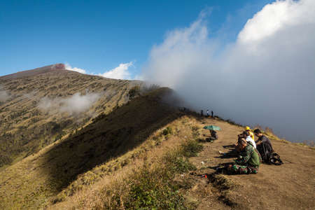 MOUNT RINJANI NATIONAL PARK, INDONESIA - JULY 22, 2016: People have rest on top of the mountain on their trekking route to Mount Rinjani on July 22, 2016 in Mount Rinjani National Park, Indonesiaのeditorial素材