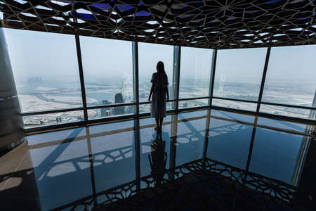 DUBAI, UAE - SEPTEMBER 5, 2018: An unidentified woman at the observation deck of Burj Khalifa on September 5, 2018 in Dubai, UAEのeditorial素材