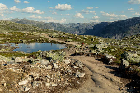 VESTLAND COUNTY, NORWAY - JULY 26, 2019: Hikers walk on the rocky footpath on their way to Trolltunga, Vestland county, Norwayのeditorial素材